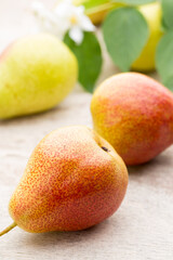 Fresh pears with leaves in a on wooden background.
