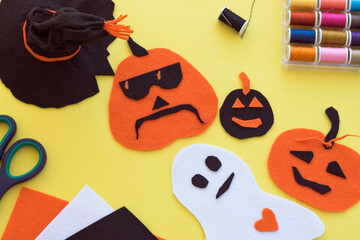 Halloween hand made DIY idea for decoration, symbols traditional for hand craft felt paper: pumpkin, ghost, spooky, witch hat in black, orange and white on yellow background