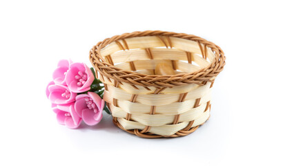 Fototapeta na wymiar Composition with wicker basket and decorative pink flowers, on white isolated background
