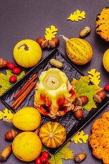 Autumn composition for Thanksgiving or Halloween with burning candle, pumpkins, acorns and fall leaves