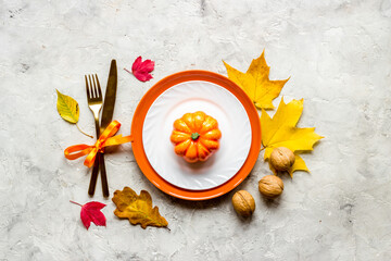Fototapeta na wymiar Thanksgiving place setting with cutlery and autumn leaves, top view