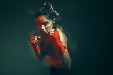 Close portrait of a female mixed martial arts fighter with a bandage on her hands. Long exposure shot