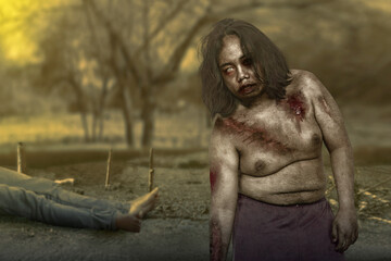 Scary zombie with blood and wound on his body with a dead man