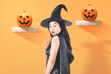 Asian witch woman with a hat standing with jack-o-lantern