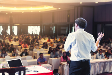 Asian businessman giving speech presentation stage meeting hall conference professional boss chief...