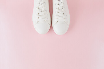 Pair of fashion stylish white sneakers, Running sports shoes on pastel pink background.
