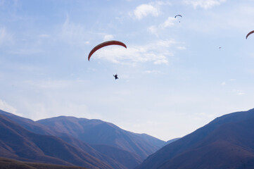 Paragliding. A man flies on a parachute against the blue sky.