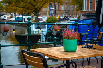 Tables and chairs in the empty caffe in the city center near canal