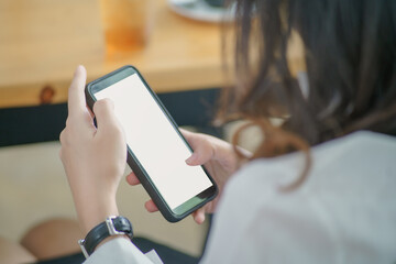 Female hand holding blank screen mobile smart phone.