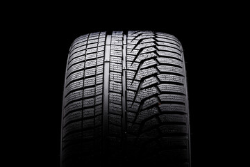 winter tire front view. Asymmetric tread pattern. re-inflating tires for the season. close-up black...