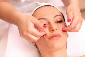 Woman undergoing a facial madero massage in spa center
