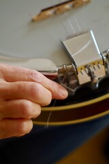 Close up of hands changing string and tuning a banjo