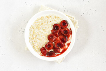 Oatmeal porridge with cherry slices in bowl