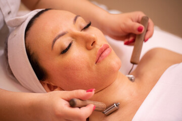 Woman getting a neck massage with facial beauty rollers