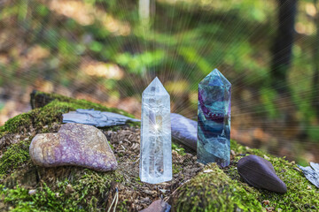 Gemstones fluorite, quartz crystal and various stones. Magic rock for mystic ritual, witchcraft Wiccan and spiritual healing on stump in forest. Meditation reiki. Ritual for love. Backlight