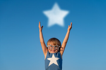 Happy child holding cloud against blue sky