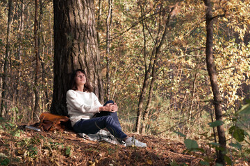 Fototapeta premium Traveler young women having a rest during hiking in the forest in autumn. Concept of safe travel.