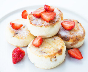 Cottage cheese cheesecakes with strawberries and powdered sugar