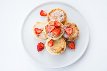 Cottage cheese cheesecakes with strawberries and powdered sugar