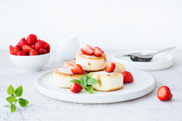 Cottage cheese cheesecakes with strawberries and powdered sugar