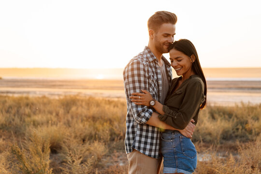 Romantic happy couple hugging and smiling while strolling on nature - Powered by Adobe
