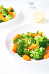 A plate of diet food, boiled vegetables, broccoli and carrots, fitness nutrition