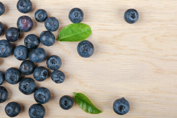 blueberries with green leaves on a wooden background