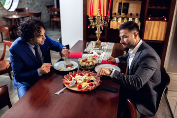 Two serious businessmen enjoying a meal