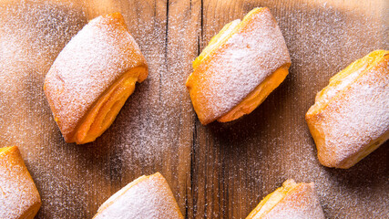 Baking strudel,rolls dusted with powder on a black and white background,on a wooden Board with a space for text,top view