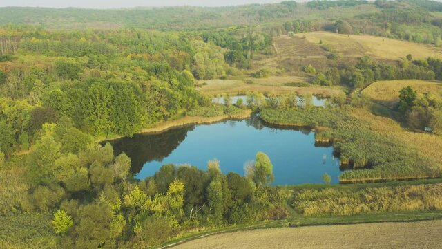 Aerial flying above stunning beautiful rural Europe landscape autumn  with fields, forests, lakes. Wonderful drone video for ecological concept.