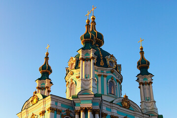 Fototapeta na wymiar Astonishing detailed view of ancient Saint Andrew Church against blue sky at sunny spring morning. Baroque style in ancient architecture. Architectural icon of the city of Kyiv, Ukraine
