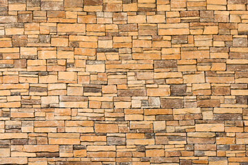 background and texture of yellow decorative stone wall surface.