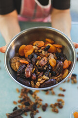 mixed nuts on green background. Apricot, grape, fig, nut. nuts in an iron bowl