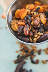 mixed nuts on green background. Apricot, grape, fig, nut. nuts in an iron bowl