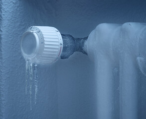 Thermostatic radiator valve with icicles showing heating system not working or not turned on.