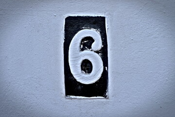 Number 6, six, white digit on a black tile, vignetted and subdued.