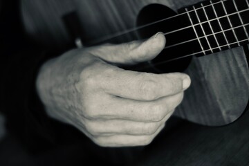 Close up of hands playing the ukulele