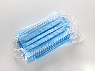 stack of disposable protective blue masks on a white background