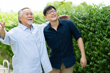 Fototapeta premium Senior Asian Father With Adult grown Son hugging outdoors