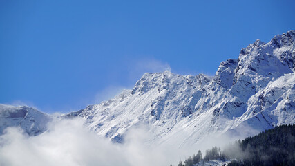 Fototapeta premium view to the alps on a foggy morning with sun and blue sky