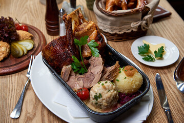 gebratene Ente im Ofen gegrillt mit Beilagen auf einem Holz Tisch in einem bayerischen Wirtshaus Biergarten  zu Weihnachten