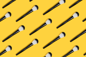 Makeup brushes pattern layout on a yellow background. Artist equipment concept.