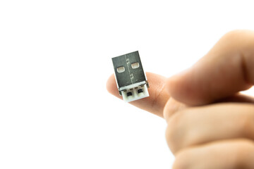 USB connector close-up photo on a man's finger on white and isolated background