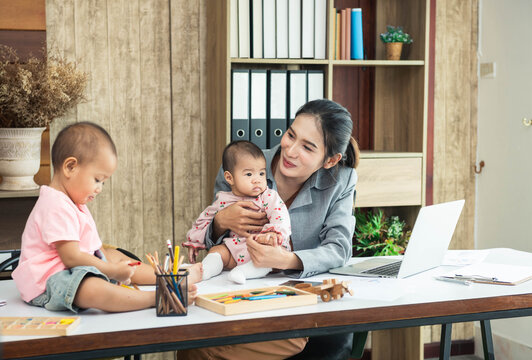 Happy Business Asian Woman Trying To Work And Talk To Her Daughter While Baby Sitting Two Kids. Single Mom Work From Home With The Children.