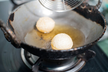 shot of north indian street food snack gol gappe pani puri or puchke being fried from dough in hot oil to make them round hollow golden ball spheres © Memories Over Mocha
