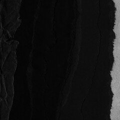 Black torn paper collage close-up. Texture made from various paper and cardboard parts. Damaged old paper background. Vintage blank wallpaper. Material design backdrop.