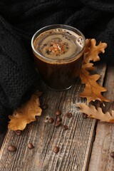 Espresso coffee with a black scarf and oak leaves on the table