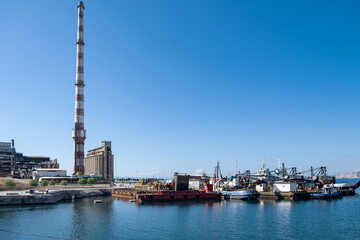 Fototapeta na wymiar Old fertilizer industrial plant and port in Drapetsona Piraeus Greece, sunny day.