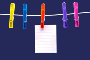 paper notepad for reminder hanging on colored clothespins