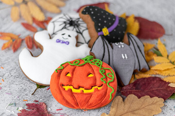 Halloween ginger cookies, leaves and spider. Halloween objects on textured close-up. Funny ginger biscuits. Soft focus